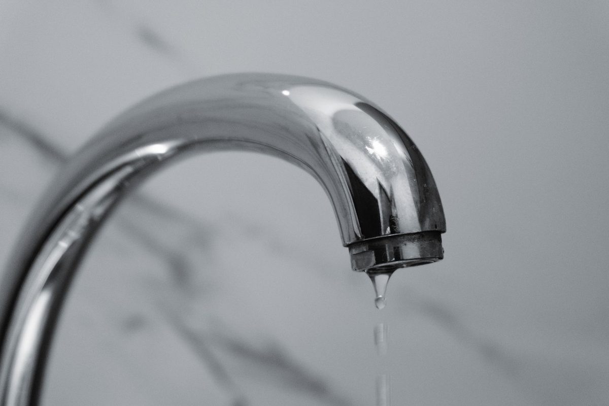 Water dripping from a chrome faucet