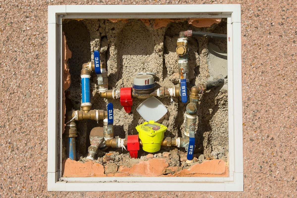 A water meter with valves and fittings in a wall box