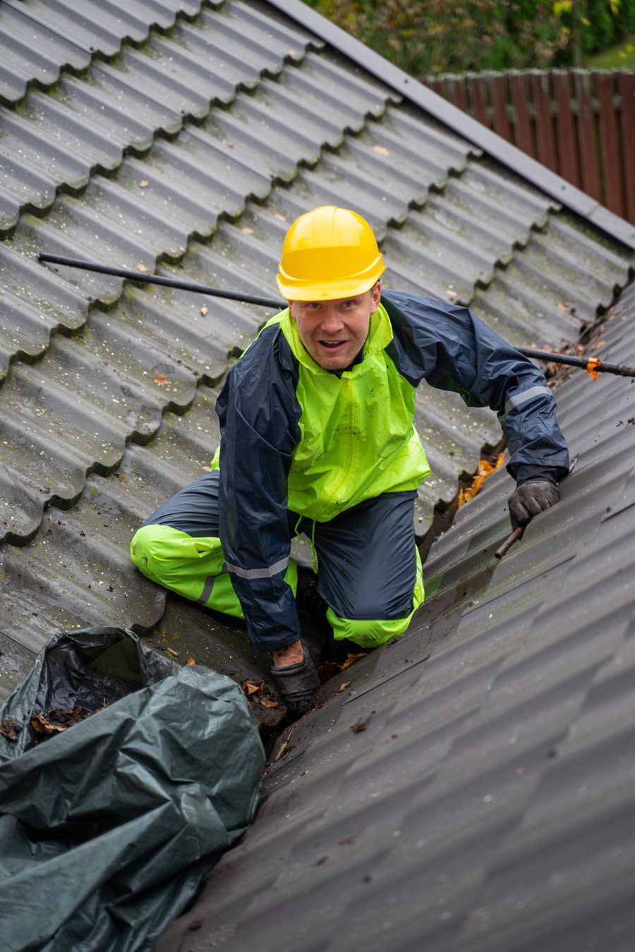 Worker in a hard hat and high-visibility jacket on a sloped roof