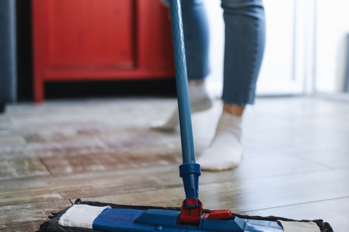 Flat mop being pushed across a wood floor