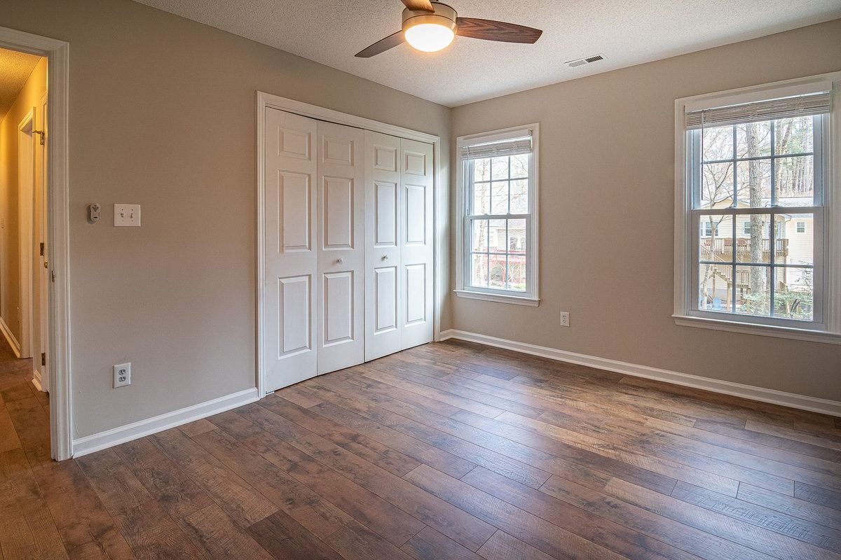 An empty bedroom with a finished hardwood floor