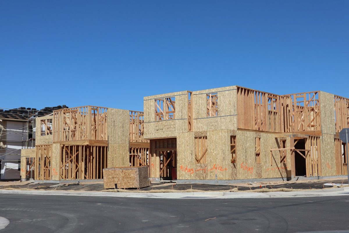 New wood-framed homes under construction with sheathing on the walls
