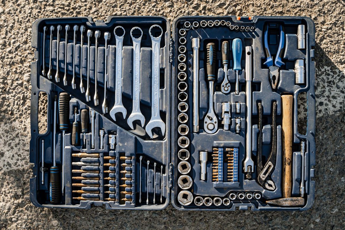 Open toolbox with rows of wrenches, sockets and screwdrivers