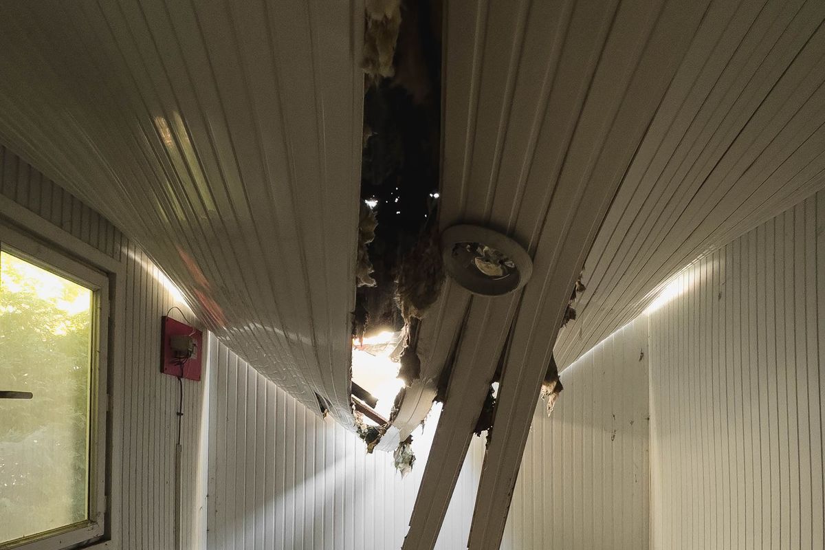 Collapsed, water-damaged ceiling with debris on the floor below
