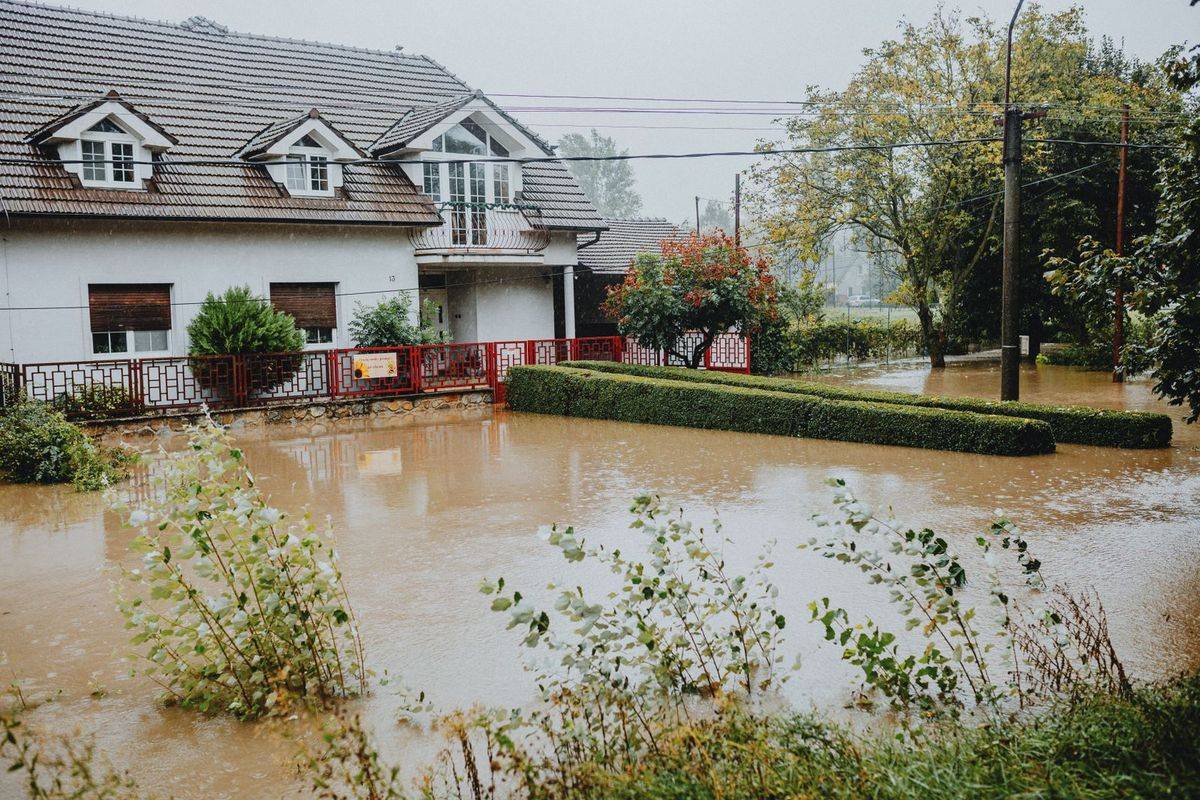 Floodwater surrounding a house and yard after heavy rain