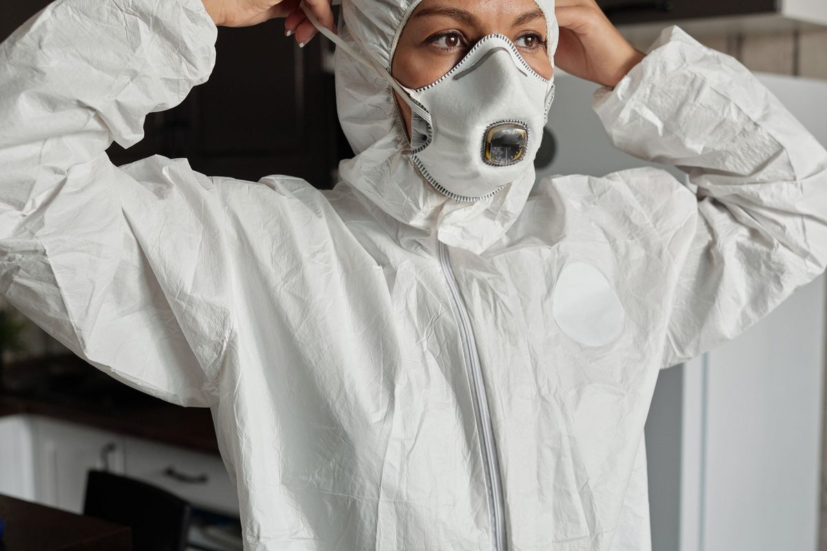 Person putting on a protective suit and respirator