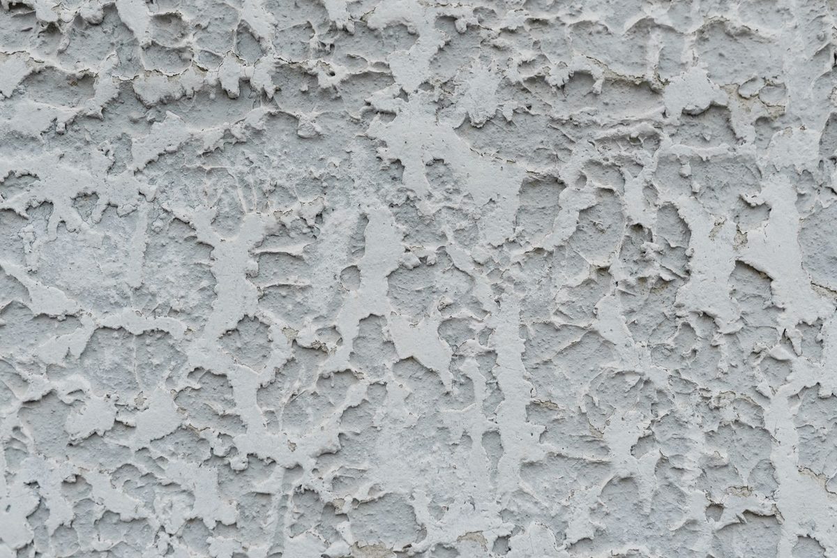 Close-up of a rough, textured gray stucco wall surface