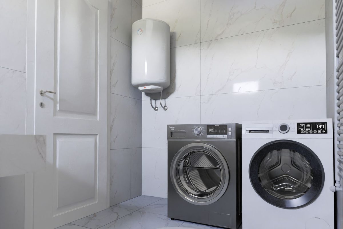 A water heater mounted on the wall of a laundry room above a washer and dryer