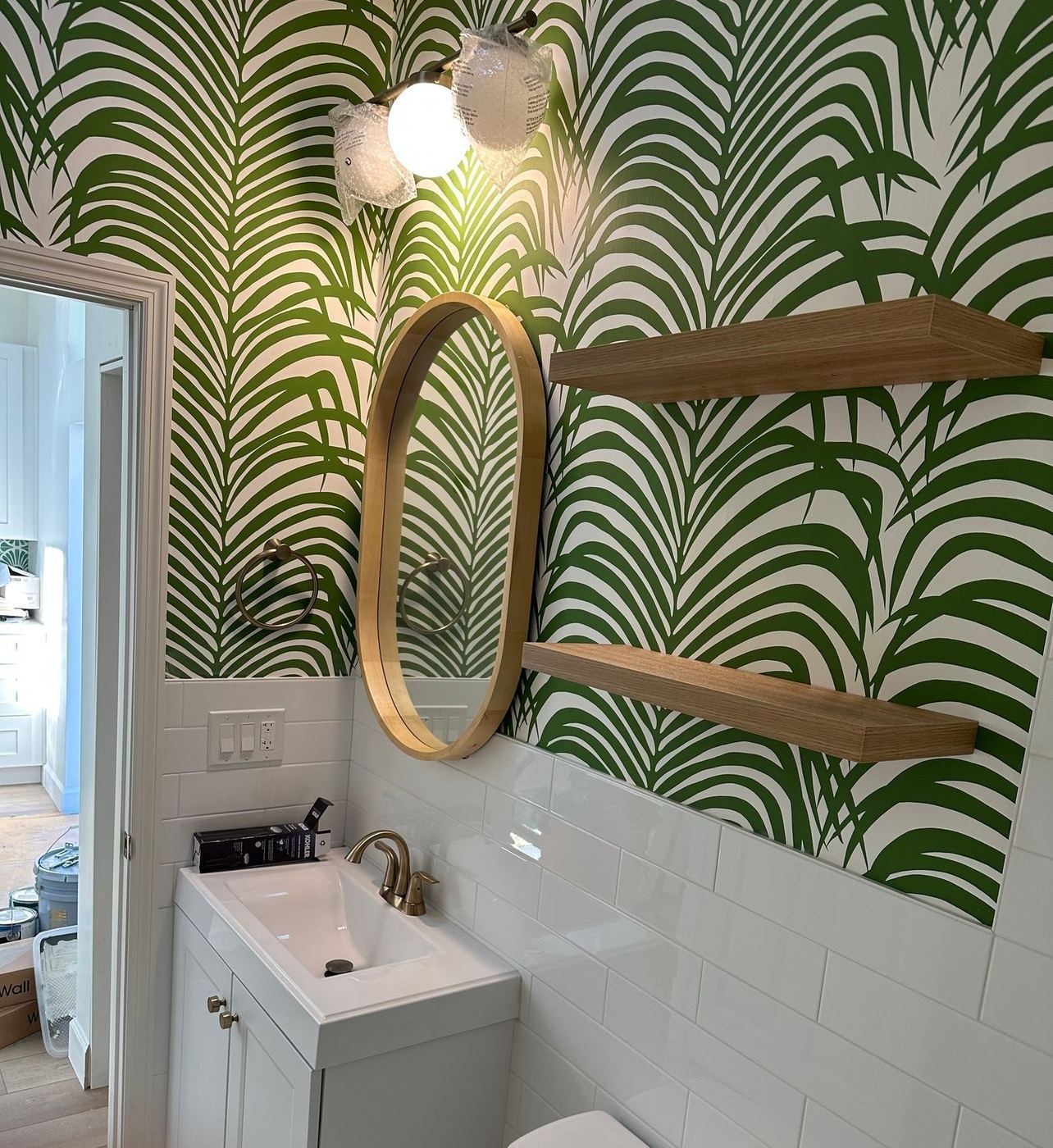 Powder room: Palm-leaf wallpaper and floating shelves
