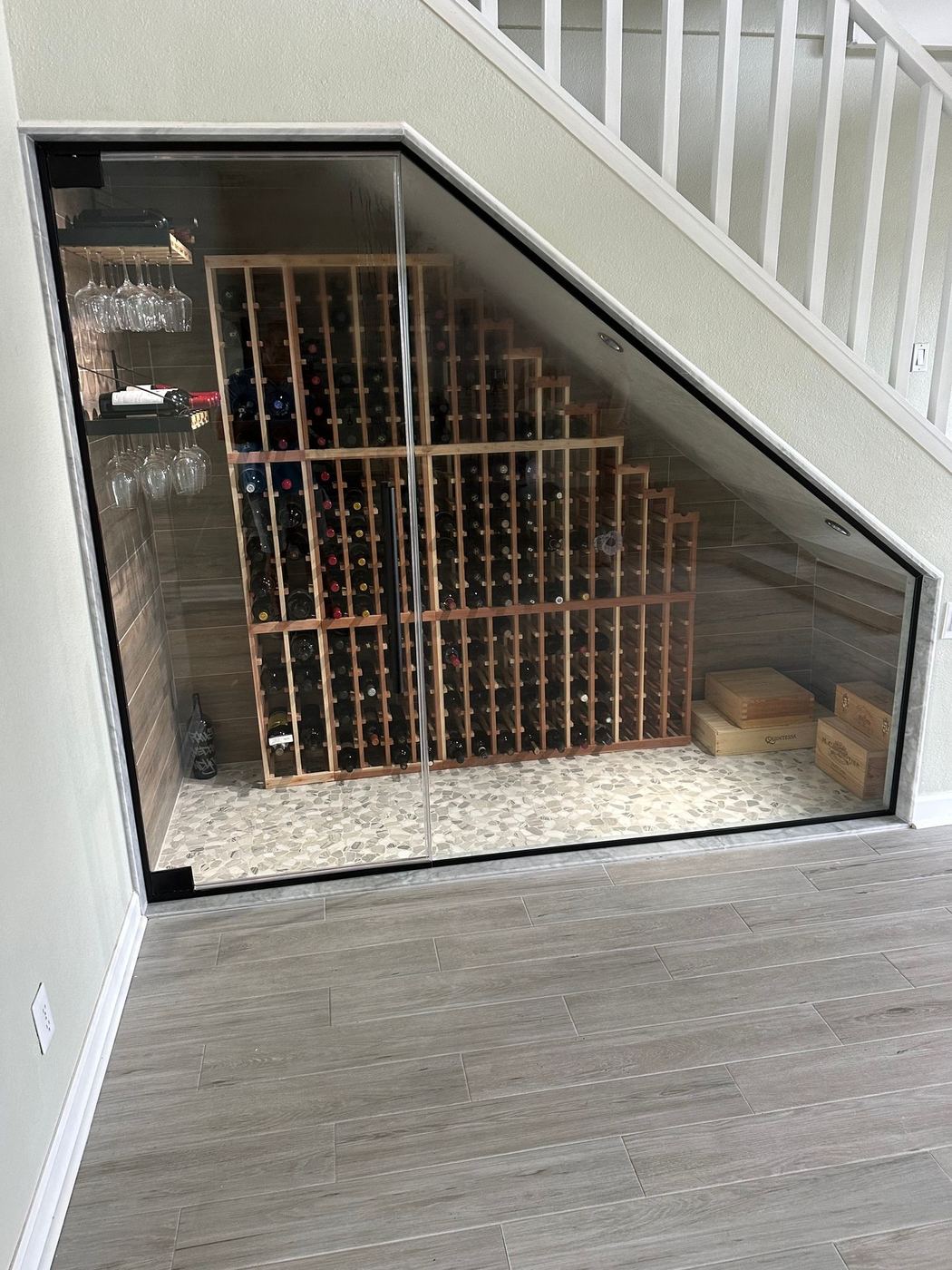 Wine cellar: Glass-enclosed cellar under the stairs